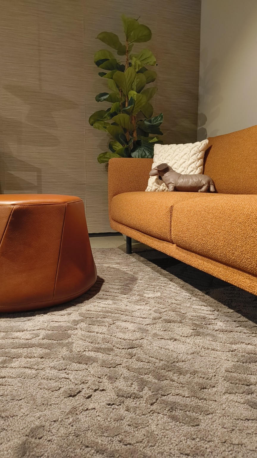 Combinatie van zachte meubelstof, cognackleurig leder en een hoogpolig karpet in de showroom